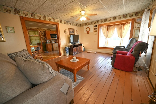 living area with ceiling fan, light wood-style flooring, and baseboards