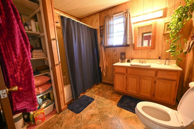 full bath with wood walls, vanity, toilet, and a shower with curtain