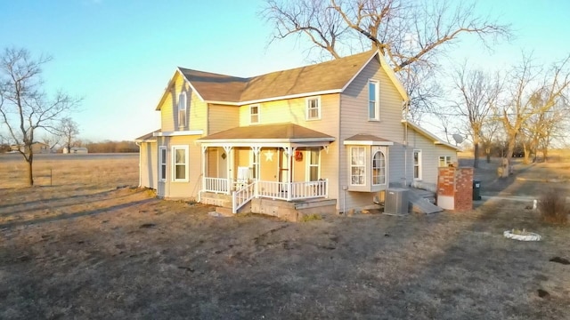 rear view of property featuring covered porch