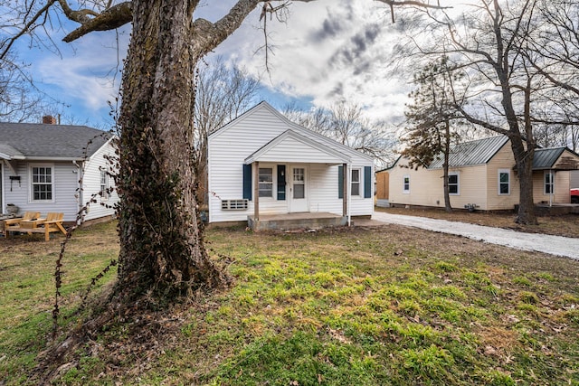 bungalow with metal roof, a porch, and a front yard