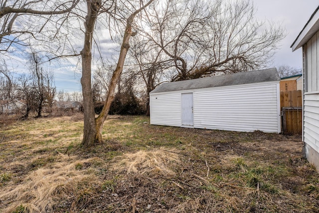 view of yard featuring an outdoor structure, a shed, and fence