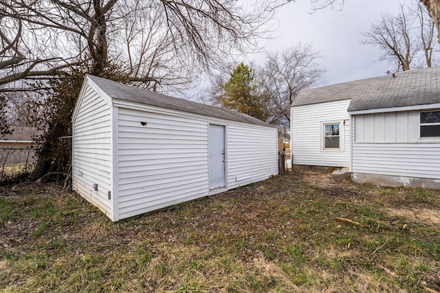 view of outdoor structure featuring fence and an outbuilding