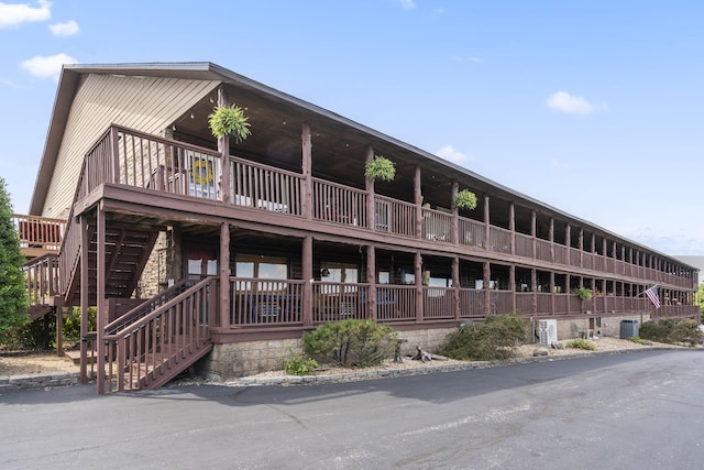 view of building exterior featuring stairs and central air condition unit