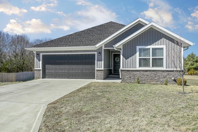 view of front of house with a garage, fence, concrete driveway, stone siding, and board and batten siding