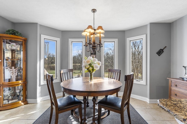 dining space with a notable chandelier, a textured ceiling, baseboards, and light tile patterned floors