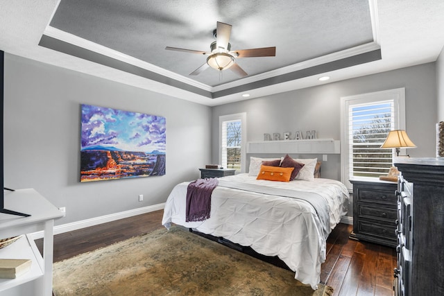 bedroom featuring dark wood-style floors, baseboards, a raised ceiling, and a textured ceiling