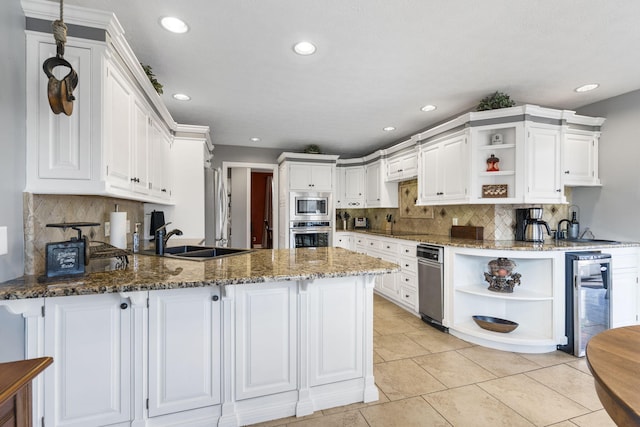 kitchen featuring beverage cooler, appliances with stainless steel finishes, a peninsula, open shelves, and a sink