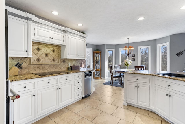 kitchen featuring white cabinets, tasteful backsplash, black electric cooktop, and a sink