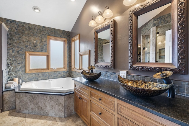 full bath featuring double vanity, vaulted ceiling, a sink, tile patterned flooring, and a bath