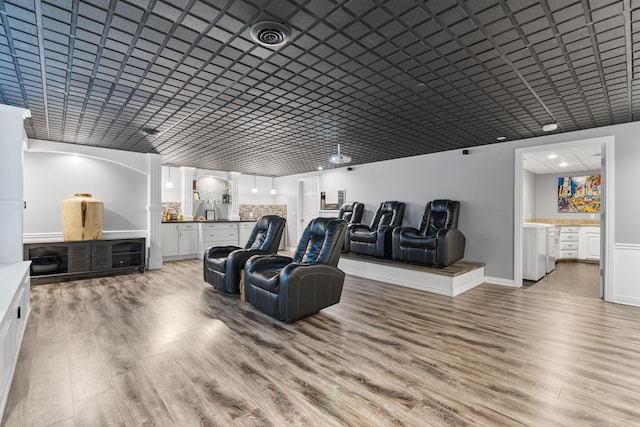 home theater with light wood-style floors, visible vents, and baseboards