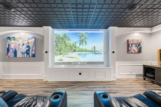 cinema room with a wainscoted wall and wood finished floors