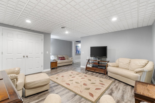 living room featuring recessed lighting, baseboards, and wood finished floors