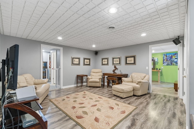 living area featuring baseboards, recessed lighting, visible vents, and light wood-style floors