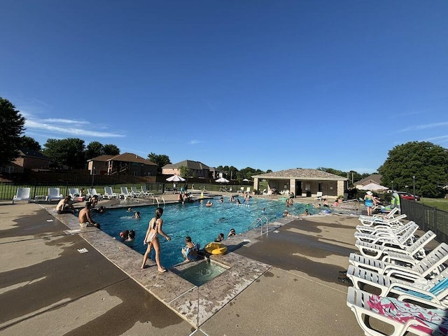 community pool featuring fence and a patio