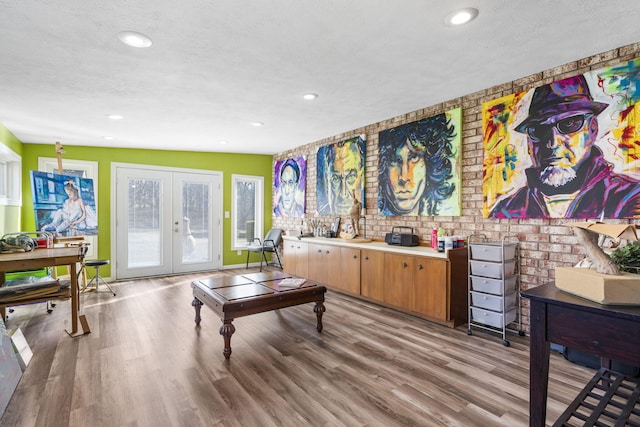 interior space with a textured ceiling, french doors, light wood-type flooring, and recessed lighting