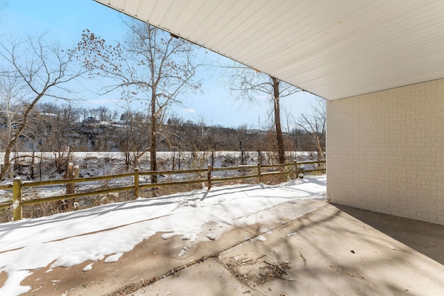 snow covered patio featuring fence