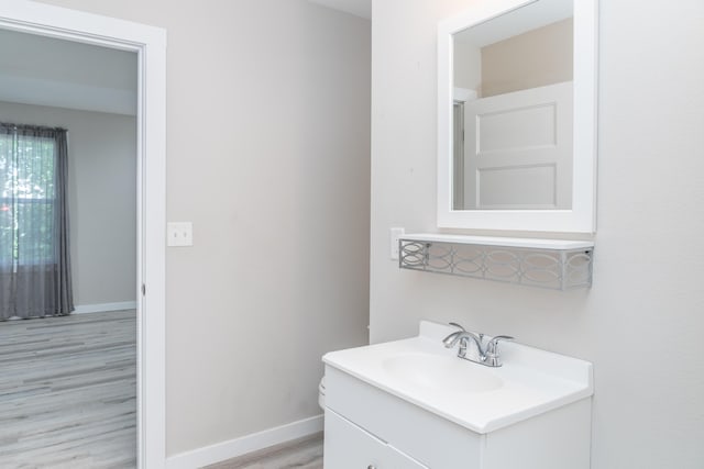 bathroom featuring vanity, baseboards, and wood finished floors