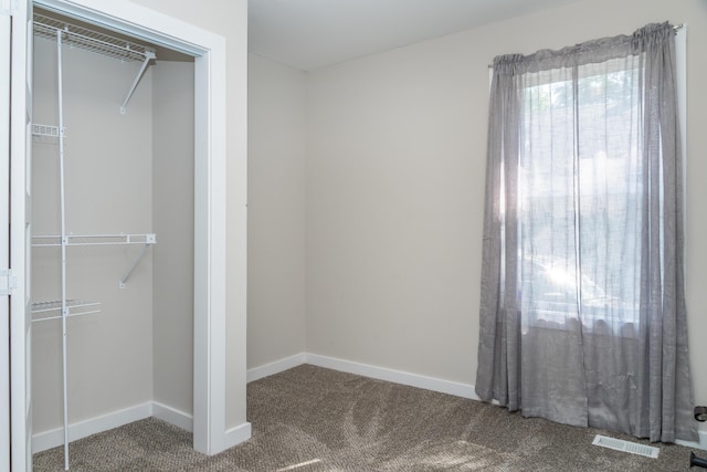 unfurnished bedroom featuring baseboards, visible vents, a closet, and carpet flooring