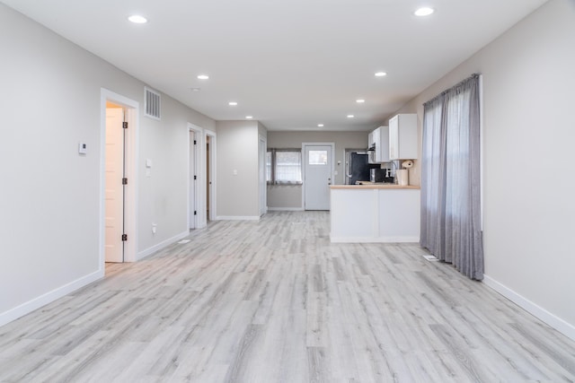 unfurnished living room with light wood finished floors, baseboards, visible vents, and recessed lighting