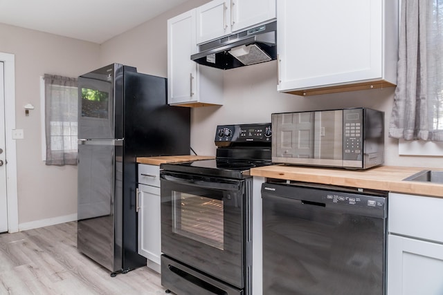 kitchen featuring black appliances, wood counters, white cabinets, and under cabinet range hood