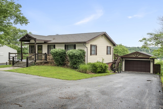 view of front of house featuring a garage, roof with shingles, an outdoor structure, a front lawn, and a porch