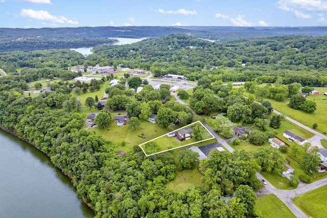 birds eye view of property featuring a water view and a wooded view