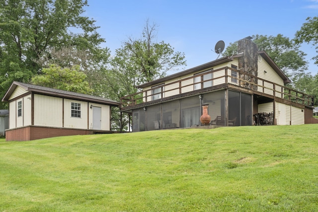 rear view of house with a sunroom, a yard, and a chimney