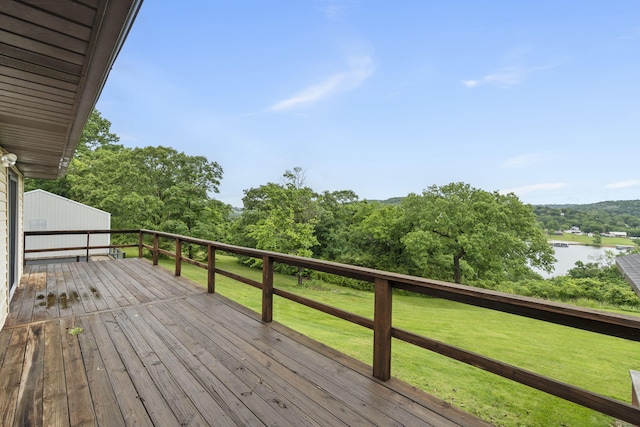 deck with a water view and a yard