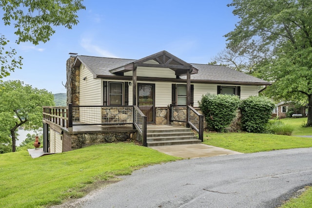 view of front facade with stone siding, a chimney, a front lawn, and roof with shingles