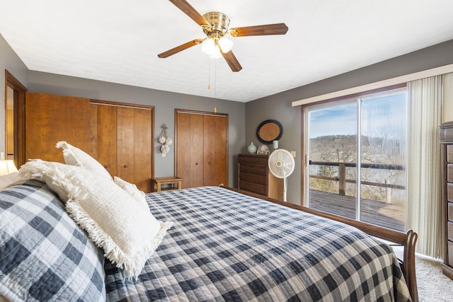 bedroom with access to exterior, a ceiling fan, multiple closets, and carpet flooring