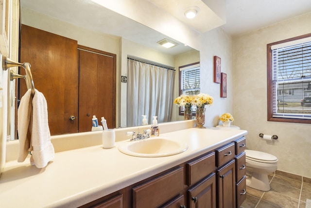 bathroom with toilet, vanity, and tile patterned floors