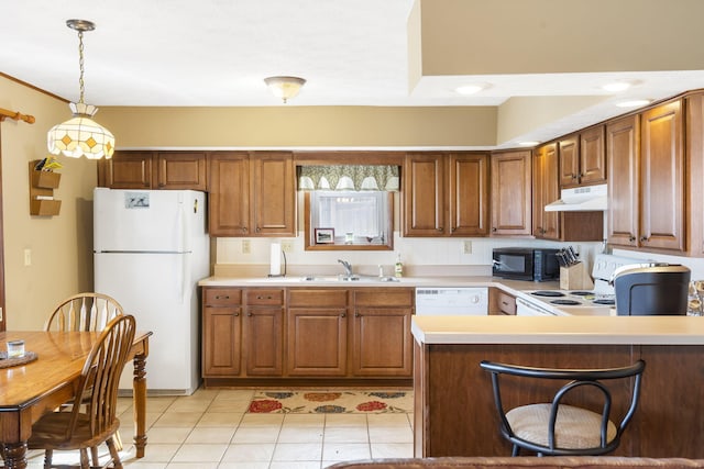 kitchen featuring white appliances, a peninsula, light countertops, under cabinet range hood, and a sink