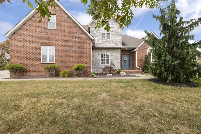 traditional home with a front yard, stone siding, and brick siding