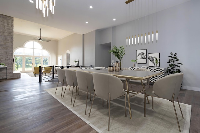 dining space with recessed lighting, a towering ceiling, a ceiling fan, wood finished floors, and baseboards