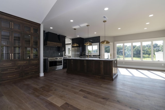 kitchen with dark wood-style floors, high quality appliances, custom exhaust hood, and light countertops