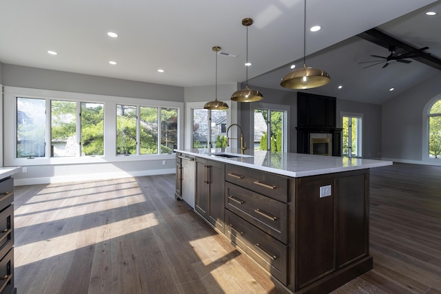 kitchen featuring dark wood-style floors, light countertops, open floor plan, a sink, and dishwasher