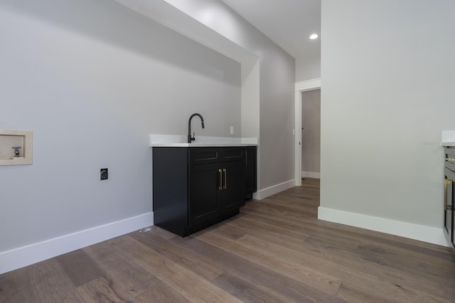 bar with a sink, baseboards, wood finished floors, and recessed lighting