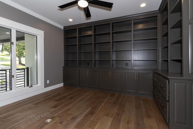 spare room with built in shelves, dark wood-style flooring, crown molding, recessed lighting, and baseboards