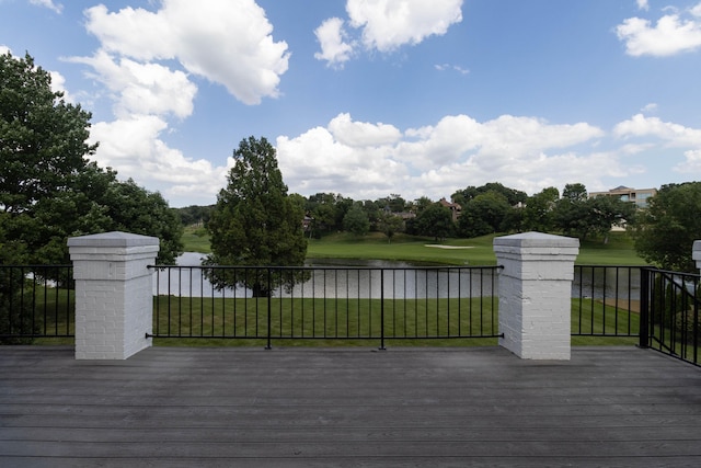 wooden terrace with a lawn and a water view