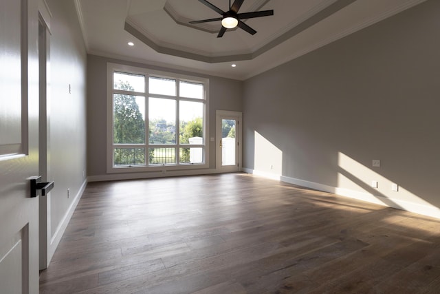 unfurnished room with a raised ceiling, ornamental molding, a ceiling fan, wood finished floors, and baseboards