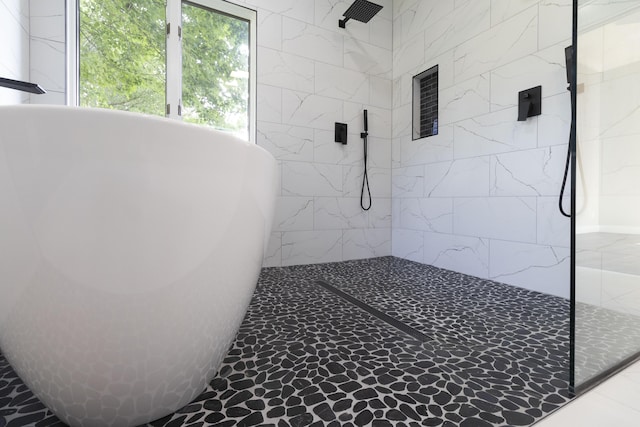 full bathroom with a soaking tub and a tile shower