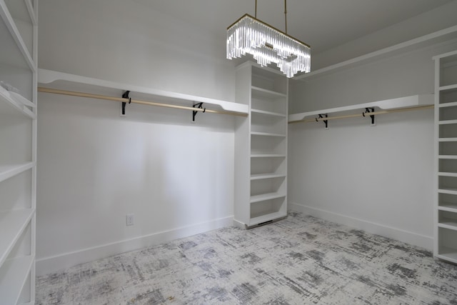 spacious closet featuring an inviting chandelier