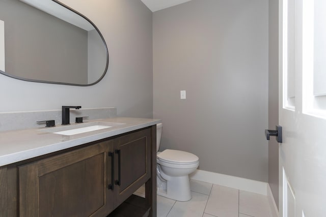 bathroom featuring toilet, tile patterned flooring, vanity, and baseboards