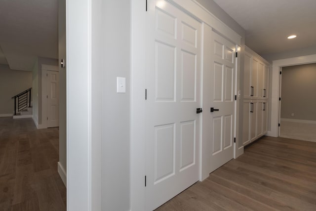 hallway with stairs, recessed lighting, baseboards, and wood finished floors