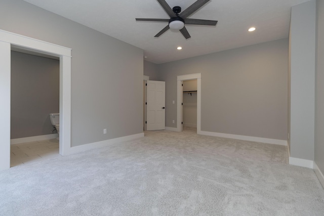 unfurnished bedroom featuring ensuite bathroom, recessed lighting, carpet floors, baseboards, and a spacious closet