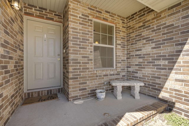 doorway to property featuring brick siding