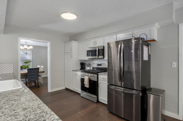 kitchen featuring stainless steel appliances, light countertops, and white cabinets