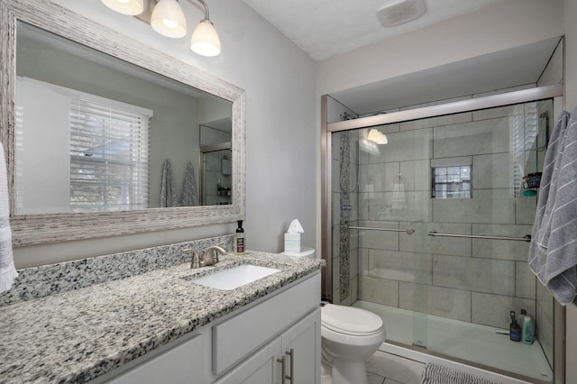 full bathroom with a shower stall, toilet, and vanity