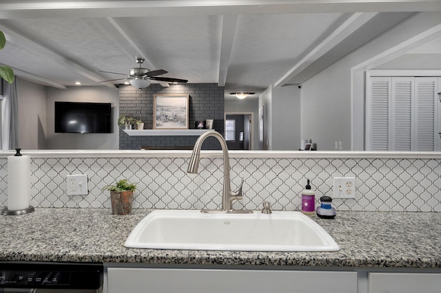 kitchen with ceiling fan, light stone counters, a sink, backsplash, and dishwasher