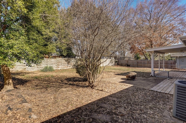 view of yard with an outdoor fire pit, a fenced backyard, and central AC